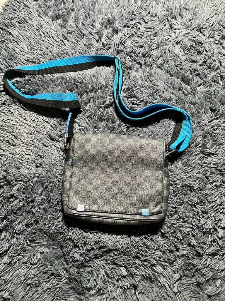 Louis Vuitton District Damier Graphite PM messenger bag featuring the iconic gray checkerboard canv…